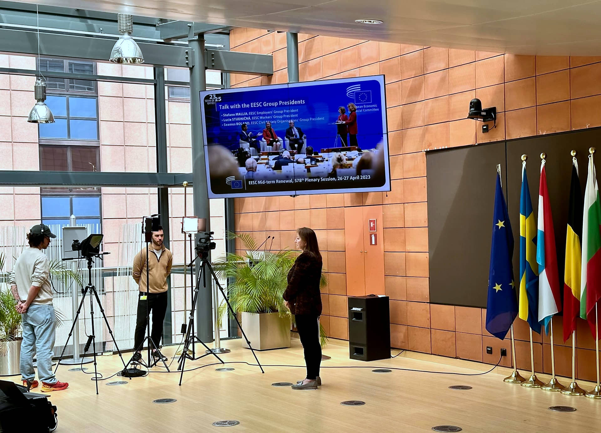 An institutional recording at the European Economic and Social Committee: camera crew filming in front of EU member state flags