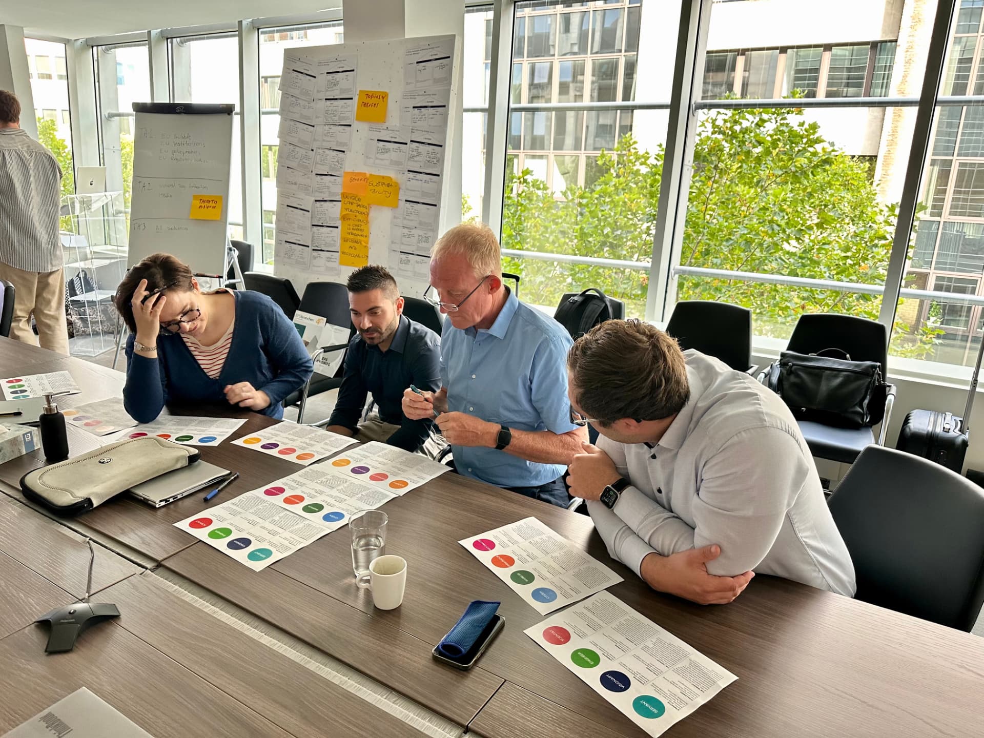 EUMEPS strategic working session: leadership and communications colleagues around a table reviewing printed priority and stakeholder sheets during a facilitated workshop in Brussels
