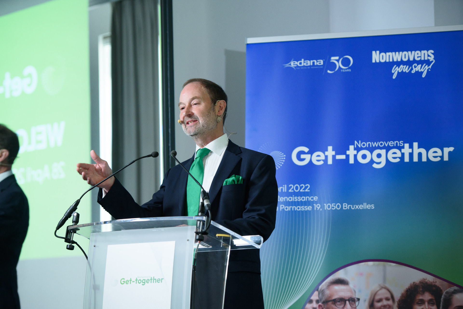 Speaker at the EDANA Nonwovens Get-together in Brussels, standing at a lectern in front of the branded 50 years campaign backdrop