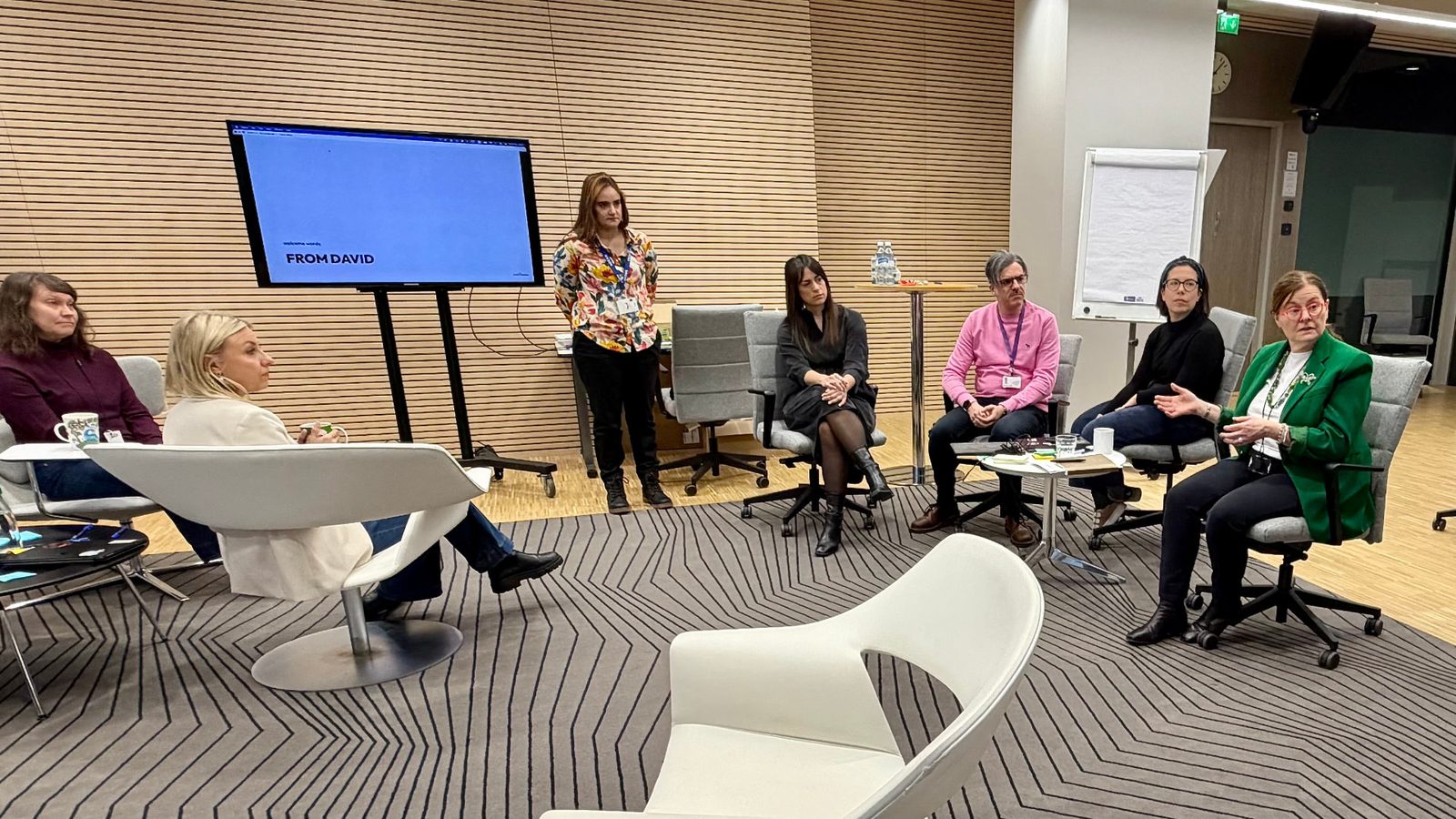 ECHA external perception and branding workshop: leadership and communications colleagues seated in a circle discussing a presentation shown on screen