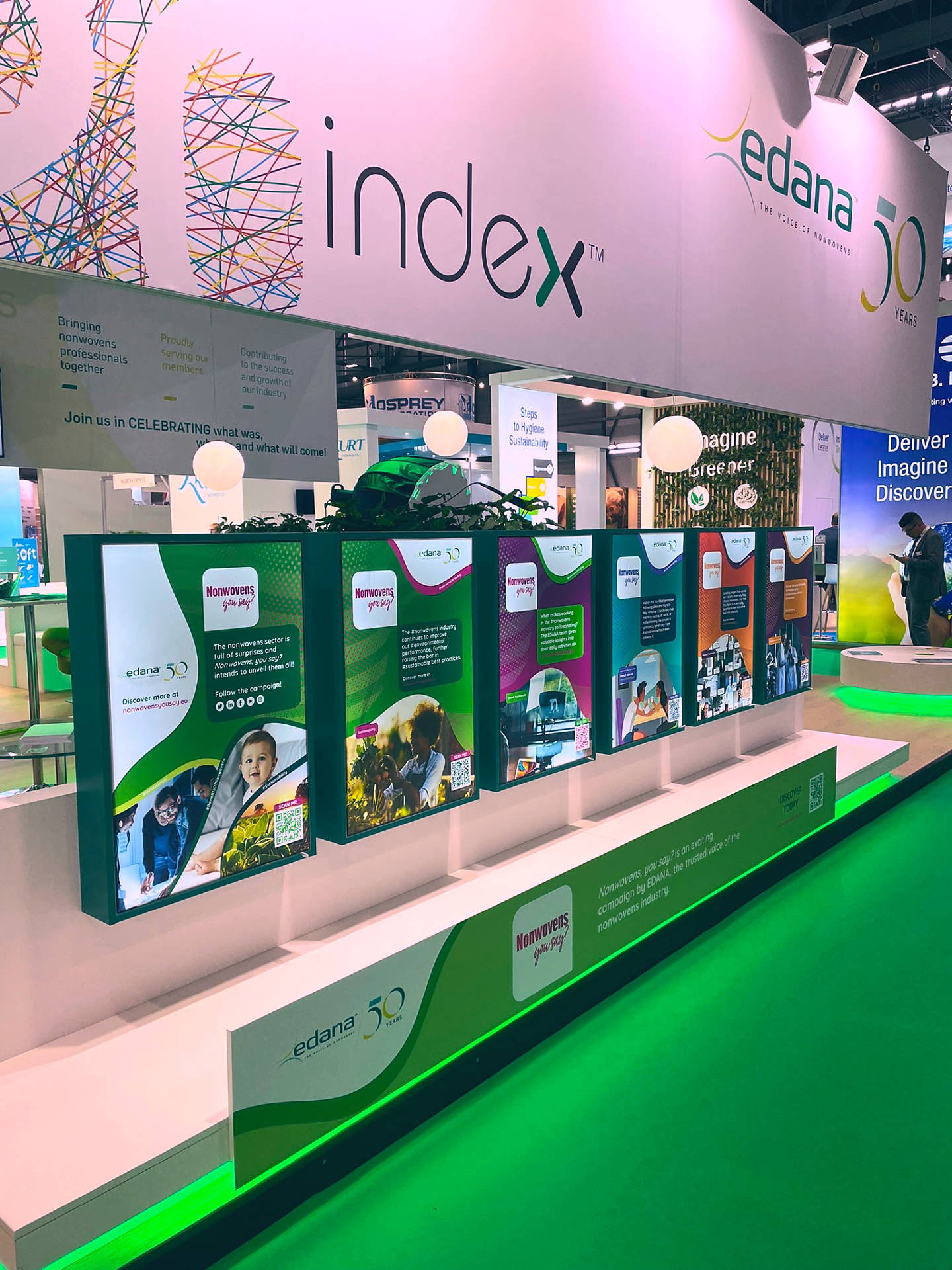The EDANA stand at INDEX: a row of illuminated campaign panels for Nonwovens, you say? under the index and edana 50 years signage