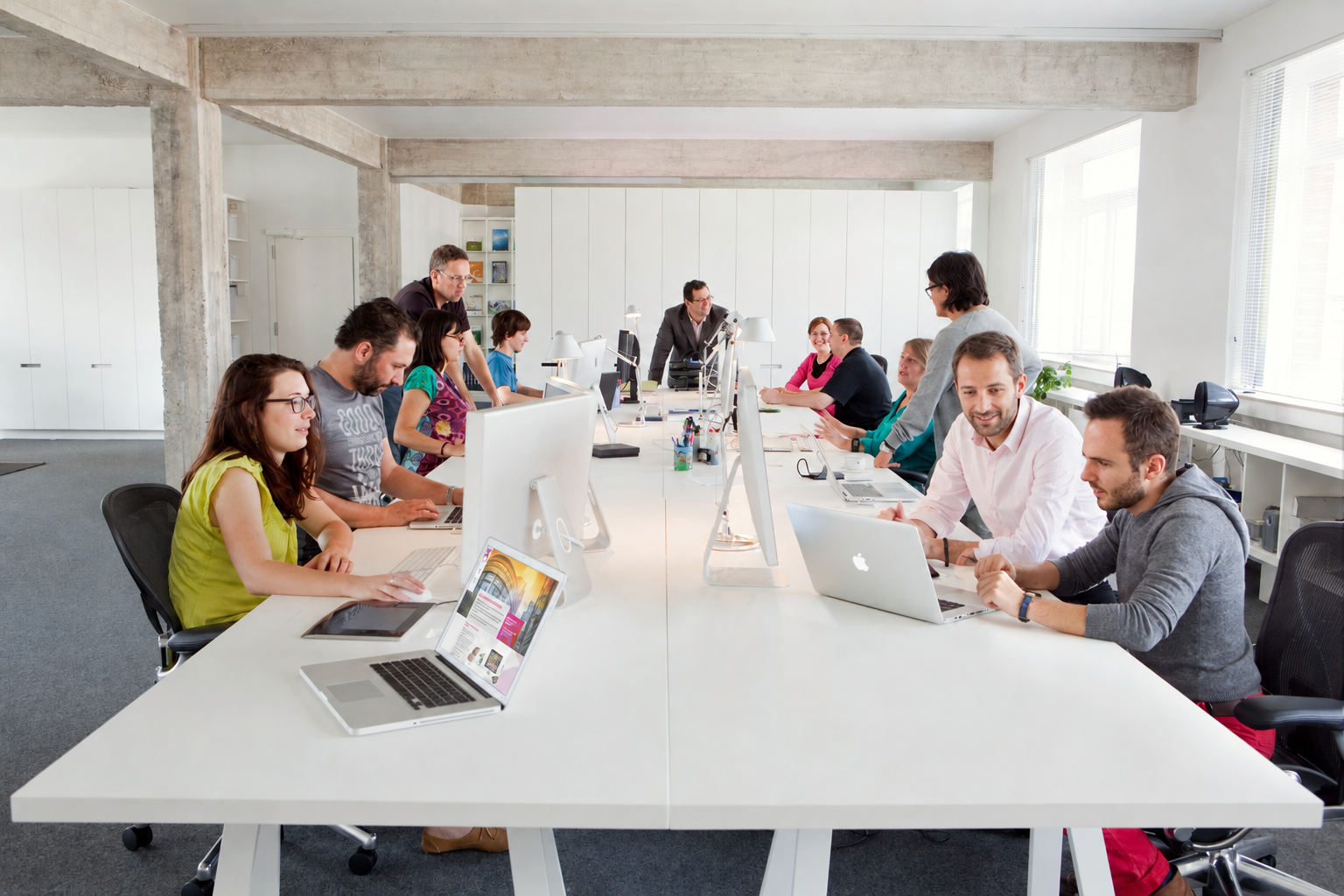 The #inextremis team at work in the Brussels studio, gathered around long white desks with laptops and screens