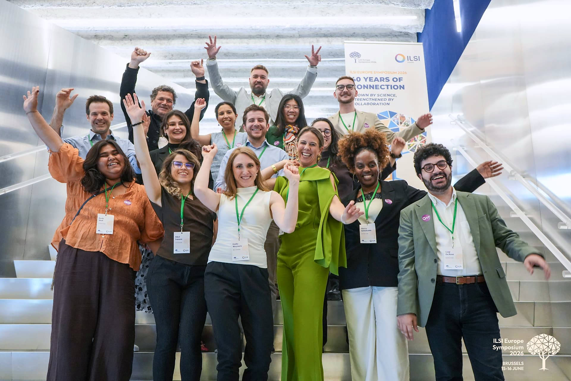 Participants of the ILSI Europe Symposium 2026 cheering on a staircase in front of the 40 Years of Connection banner in Brussels