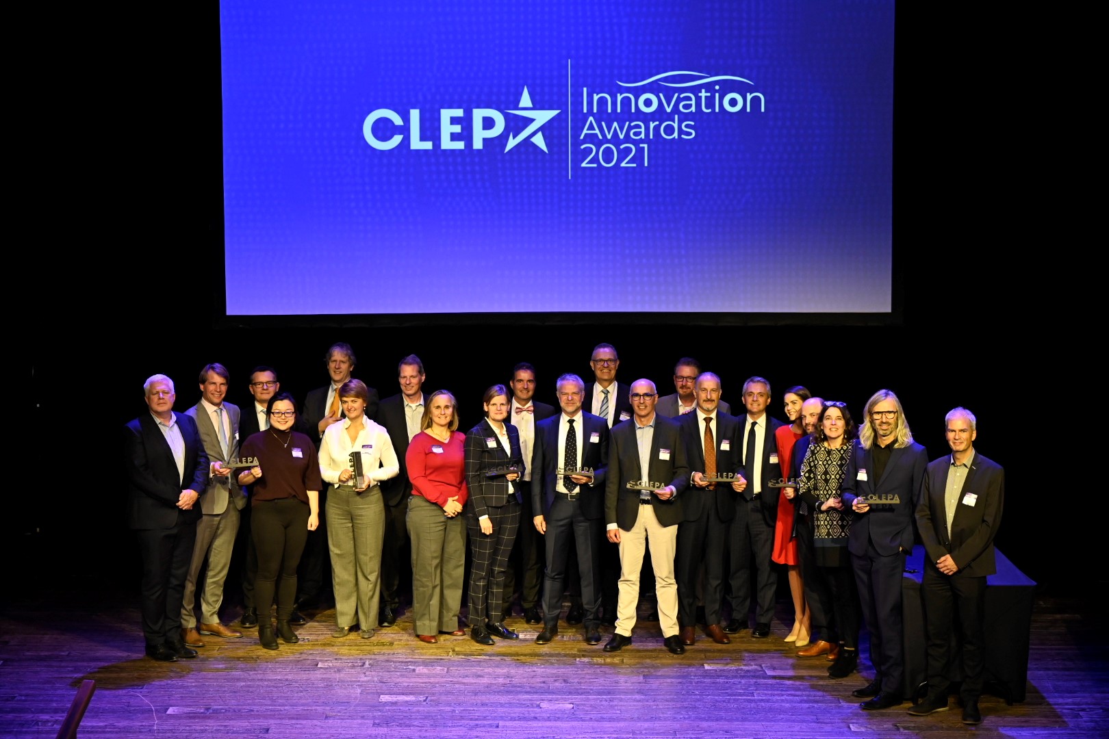 Winners of the CLEPA Innovation Awards 2021 on stage with their trophies in front of the illuminated awards screen